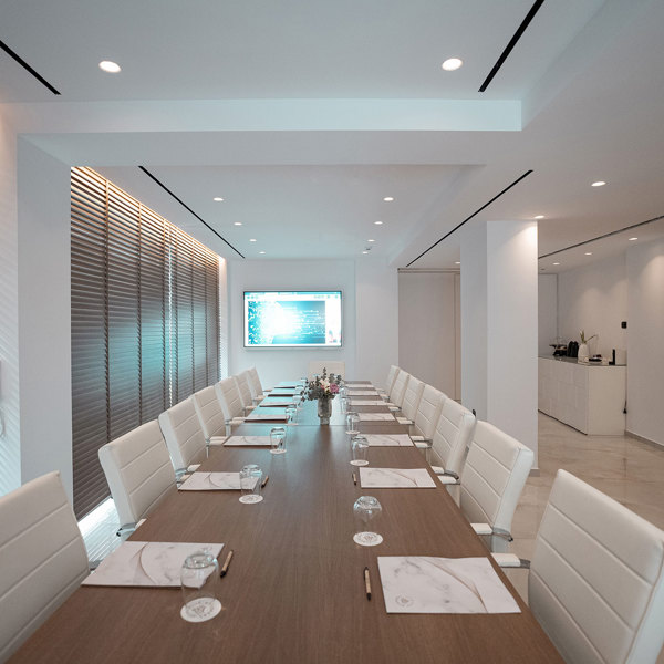 Ethereal White Resort Heraklion Meeting Room room with large wooden table and white office chairs and the blinds are down